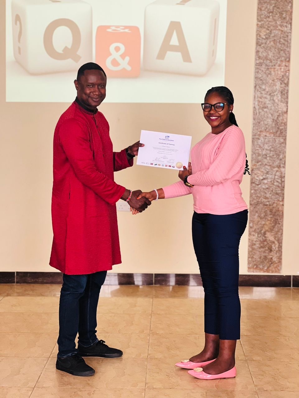 Facilitator presenting a Certificate of Training to a smiling participant